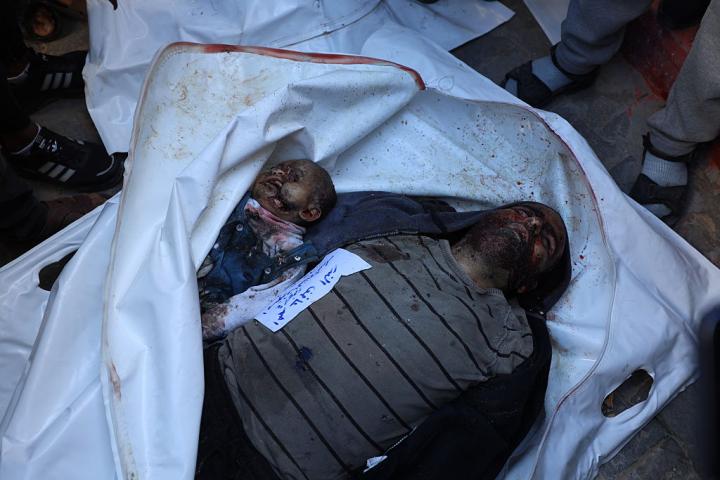 Los cuerpos de un adulto y un niño, muertos por un ataque de Israel a una escuela convertida en refugio en el este de la ciudad de Gaza, el 20 de diciembre de 2025.