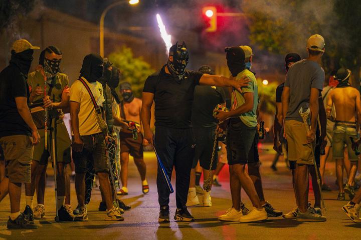 Manifestantes con máscaras y pasamontañas portan cadenas, palos y bates de béisbol durante una noche de disturbios, el 14 de julio de 2025, en Torrepacheco (Murcia).