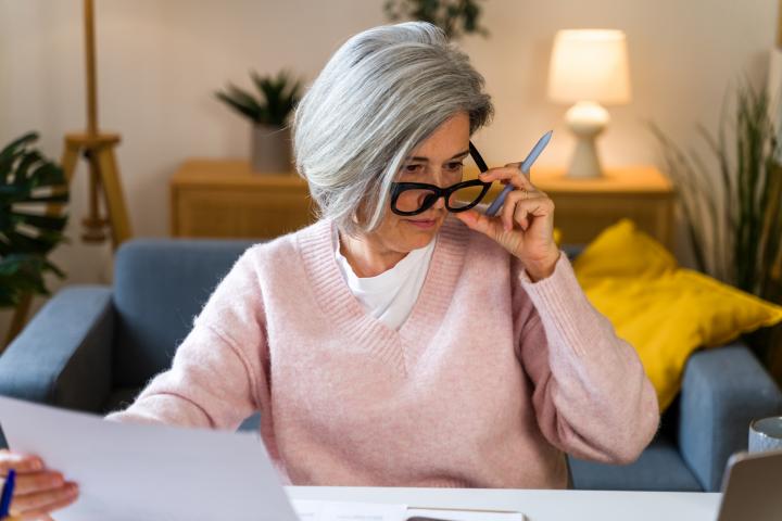 Una mujer se sujeta las gafas frente al ordenador