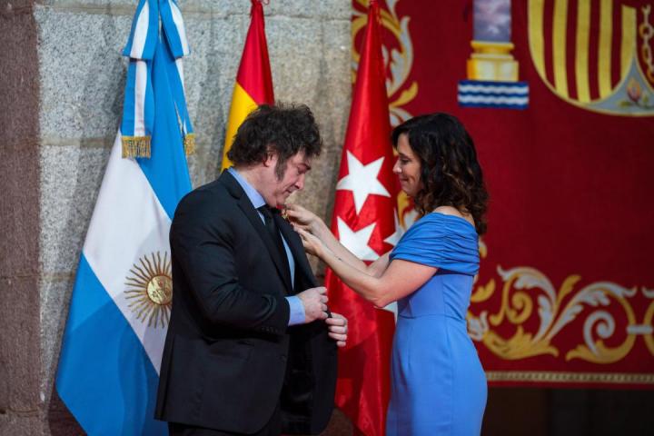 Ayuso colocando la medalla internacional de la Comunidad de Madrid a Javier Milei.