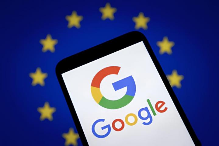 El logotipo de Google se muestra en la pantalla de un teléfono inteligente con una bandera de la UE de fondo.