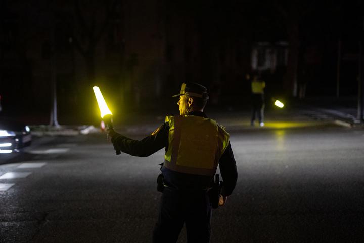 Un policía gestiona el tráfico con señales reflectantes durante el apagón