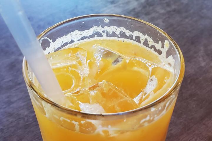 Imagen de archivo de un zumo de naranja con una pajita.