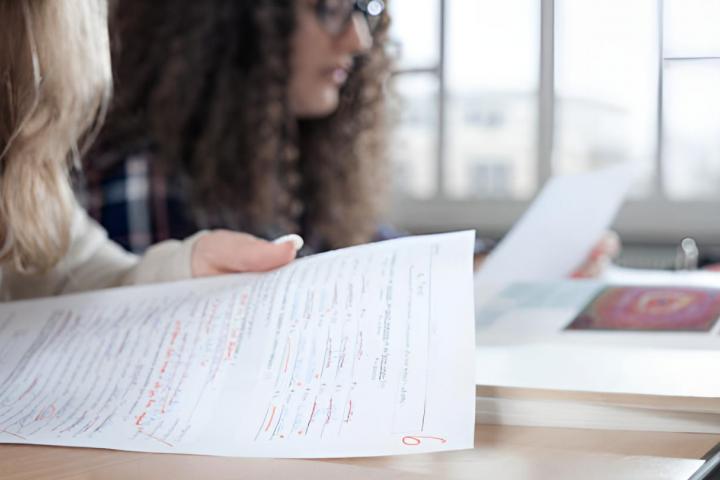 Unas alumnas viendo sus exámenes corregidos