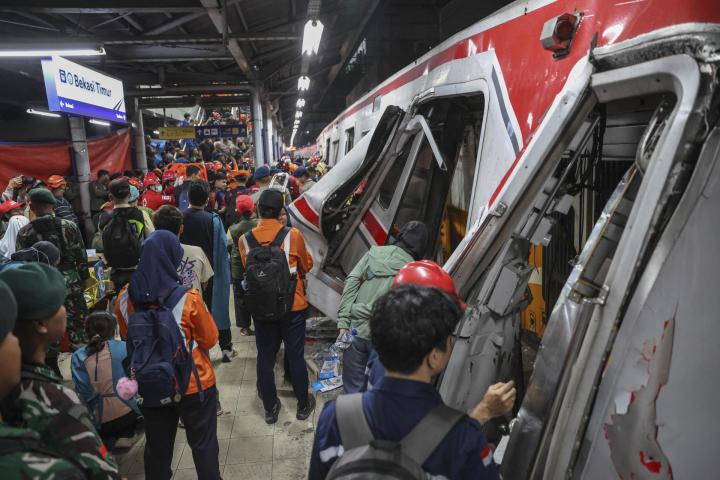 Equipos de rescate trabajan para evacuar a los pasajeros atrapados entre los restos de dos trenes que colisionaron en la estación de tren de Bekasi Este, en Java Occidental, Indonesia, el 28 de abril de 2026.