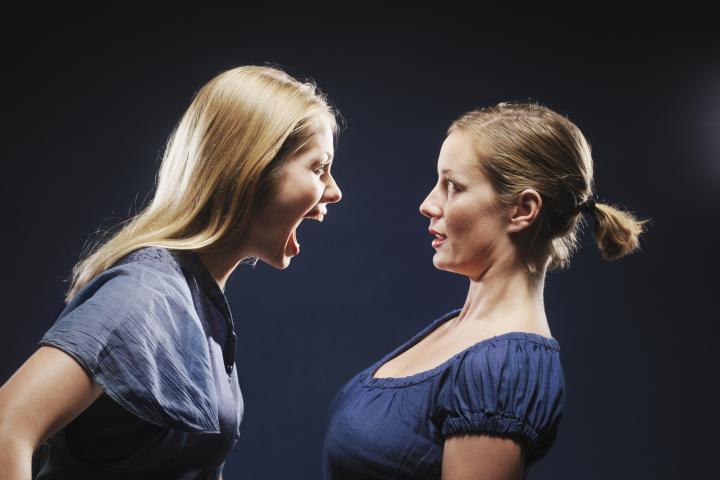 Mujer gritándole a otra mujer, vista lateral