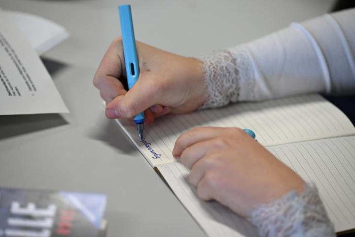 Persona escribiendo a través de un bolígrafo.