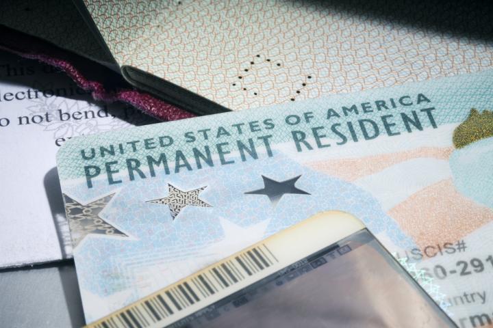 Primer plano de una tarjeta de residente permanente de EEUU (la llamada tarjeta verde), entre varios documentos oficiales.