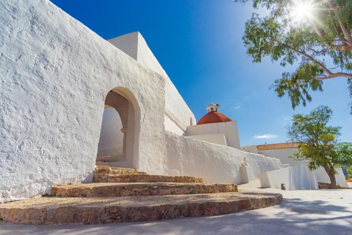 View of the old town church of Santa Eulària des Riu in the east of Ibiza, bright light, clear blue sky. Developed from RAW.