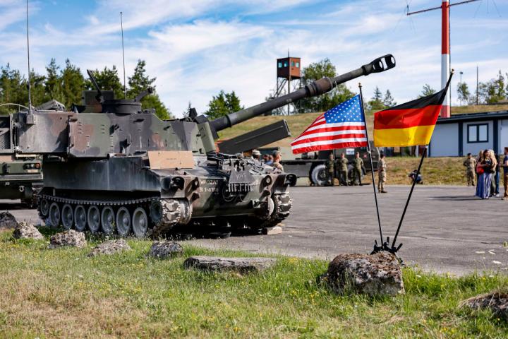 Un tanque Paladin estadounidense, detrás de dos banderas, una de EEUU y otra de Alemania, durante un ejercicio de 19 naciones en el campo de entrenamiento de Grafenwöhr, en Baviera, el 20 de julio de 2022.