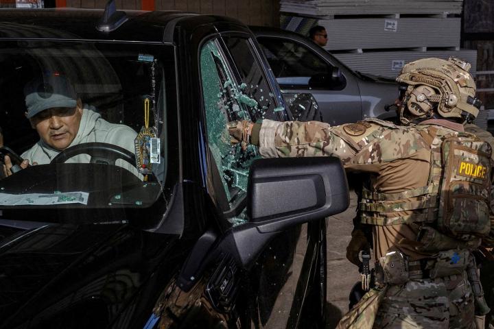 Agentes federales rompen la ventanilla de un coche para intentar detener a un hombre durante una redada de inmigración, el 17 de diciembre de 2025, en Chicago (EEUU).