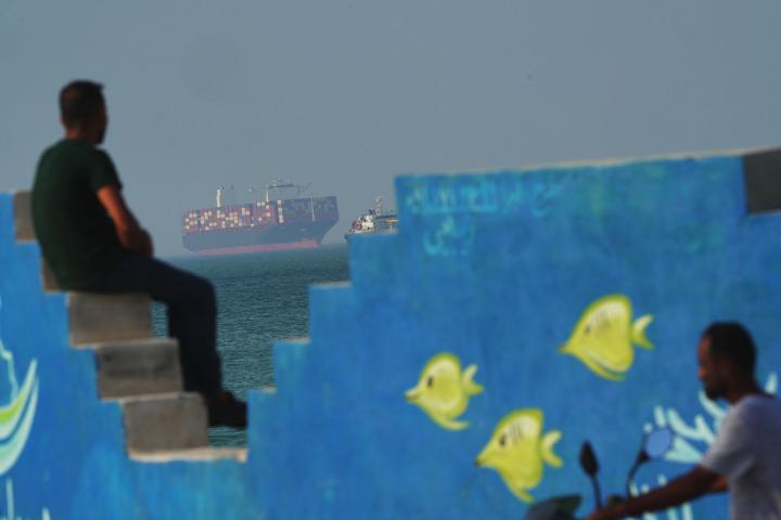 Un carguero navega tras un mural que representa peces en la costa de la isla de Qeshm, Irán, en el estrecho de Ormuz, el 28 de abril de 2026.