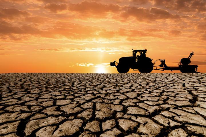 Una ilustración de un tractor sobre un terreno seco y desertificado