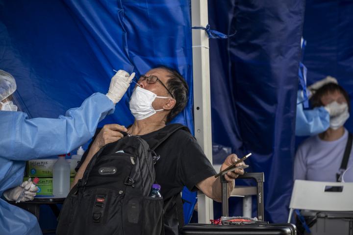 Un sanitario hace una PCR a un paciente