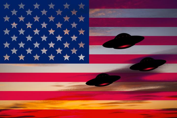 Tres objetos voladores no identicados (ovnis), sobre una bandera de EEUU, en una ilustración.