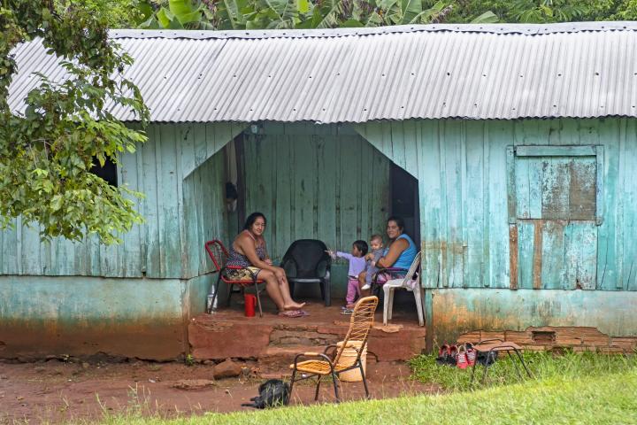 Familia posando junto a una cabaña de madera con techo de chapa ondulada en una aldea rural cerca de Ciudad del Este, Alto Paran‡, Paraguay.