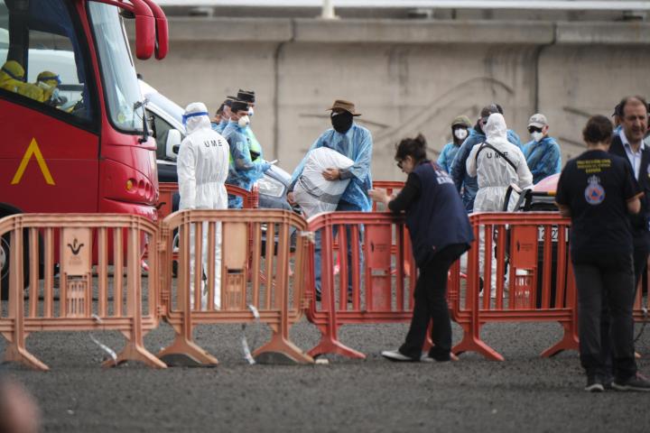 Los pasajeros evacuados este domingo por la tarde del crucero MV Hondius en el puerto de Granadilla de Abona (Tenerife) se dirigen con sus pertenencias personales al autobús de la Unidad Militar de Emergencias