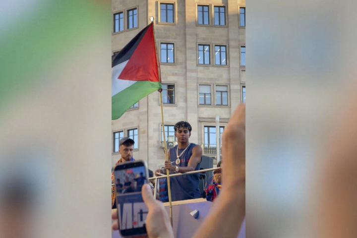 El delantero del Barcelona Lamine Yamal ondeó este lunes una bandera de Palestina durante la rúa de celebración del título de LaLiga
