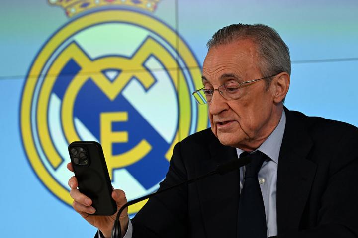 Florentino Pérez mira el móvil durante su intervención