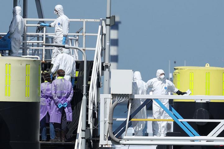 Personal médico con ropa aislante atiende a los tripulantes del MV Hondius a su llegada a Róterdam