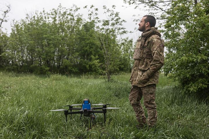 Un militar ucraniano prepara un dron en una zona boscosa