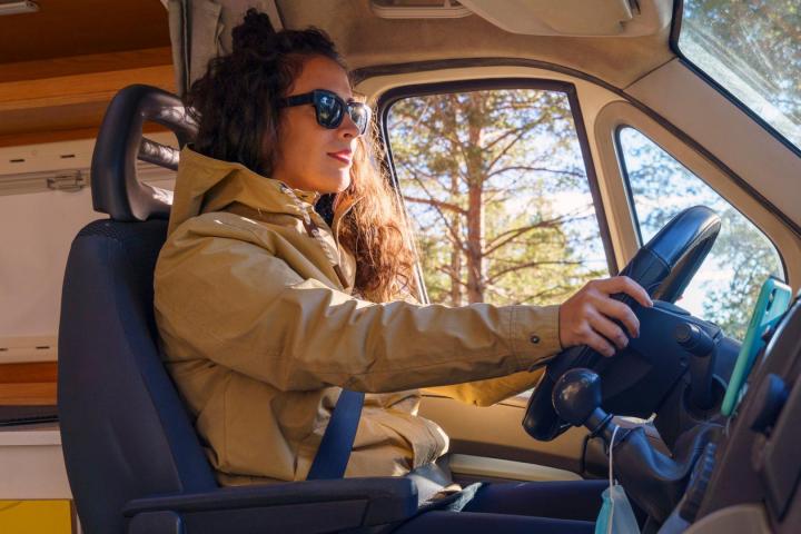 Mujer conduciendo una caravana en la naturaleza