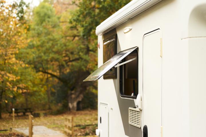 Una autocaravana con la ventana abierta en otoño.