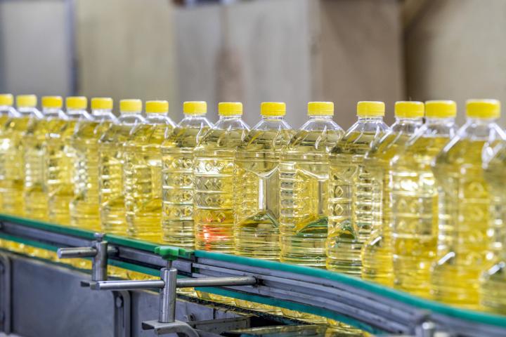 Botellas de aceite de cocina en una línea de producción.