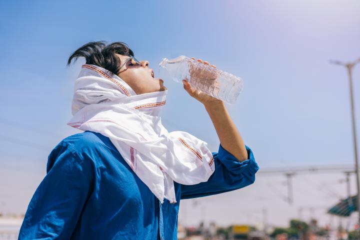 Una mujer bebiendo agua en una ola de calor