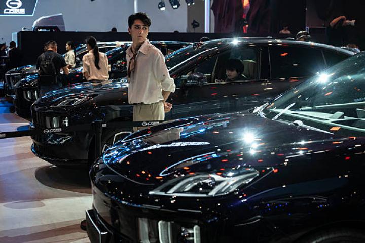 BEIJING, CHINA - APRIL 24: A host stands next to a new electric car from Chinese automaker Hyptec as it is displayed on media day at the Beijing International Auto Exhibition on April 24, 2026 in Beijing, China.The biennial showcase, held at the China International Exhibition Center, brings together leading global and domestic automakers to unveil their latest models, concept vehicles, and electric mobility innovations for the world's largest automotive market. (Photo by Kevin Frayer/Getty Images)