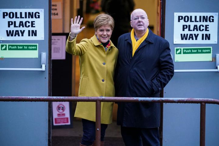 La primera ministra de Escocia y líder del SNP, Nicola Sturgeon, vota junto a su esposo Peter Murrell en Ballieston (Glasgow), en diciembre de 2019.