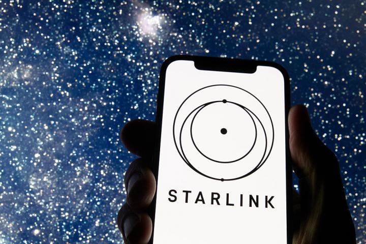 Logo de Starlink en un móvil, sobre un fondo estrellado
