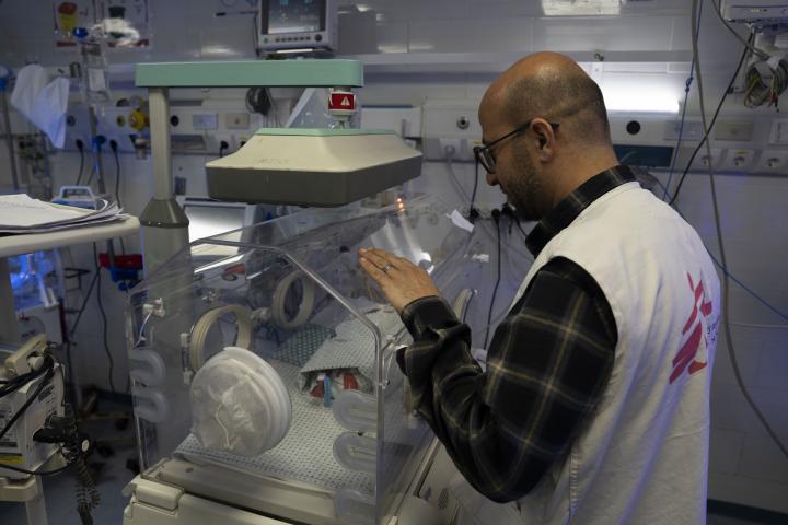 Mohammed Shehada, jefe de actividades de enfermería de MSF en el hospital Al-Helou, de Gaza, examina a un recién nacido con bajo peso que yace en una incubadora.