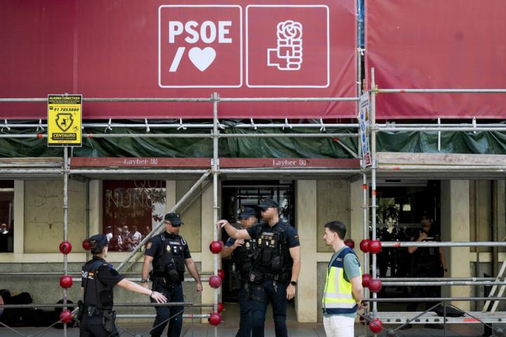 Fuerzas y Cuerpos de Seguridad del Estado vigilan la entrada de la sede del PSOE durante las labores de la UCO en su interior