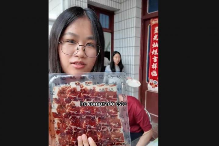 Jin da para probar a su familia de China un plato de melón con jamón.