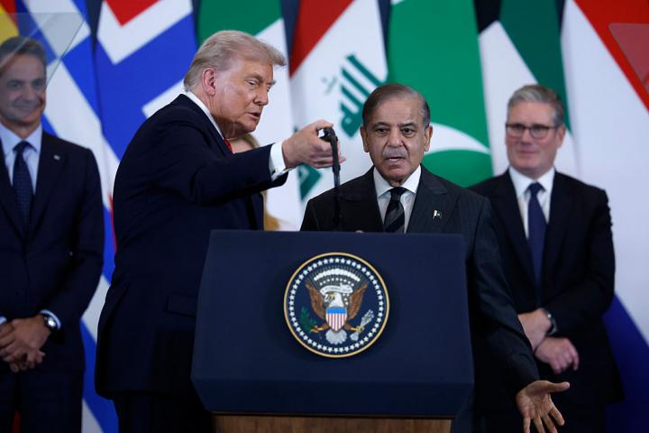Donald Trump tratando de encender un micrófono en presencia de otros líderes internacionales