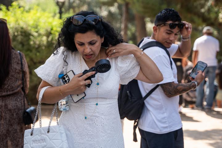 Una mujer camina en la calle en un día caluroso
