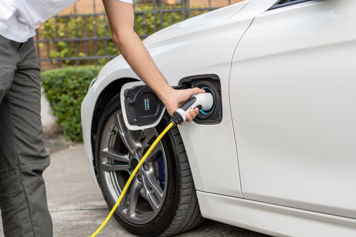 Una persona cargando un coche eléctrico, en una imagen de archivo