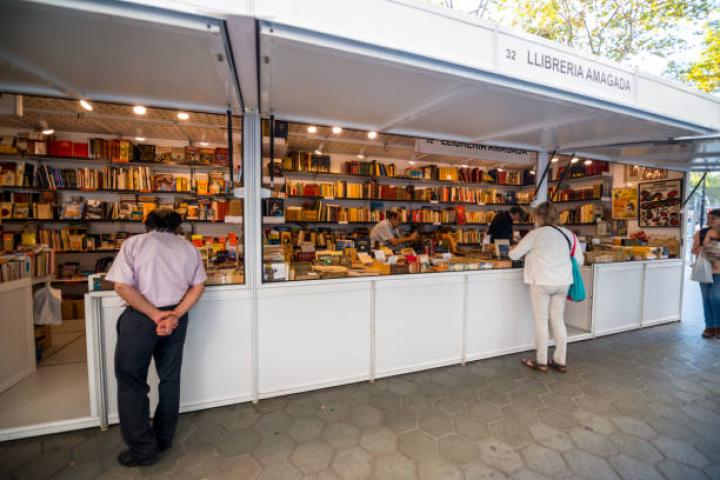 alt="alt="Barcelona, Spain - September 29, 2016: People shopping on famous Passeig de Gracia, shopping street full of trendy shops. Outdoor book store, people choosing books.""