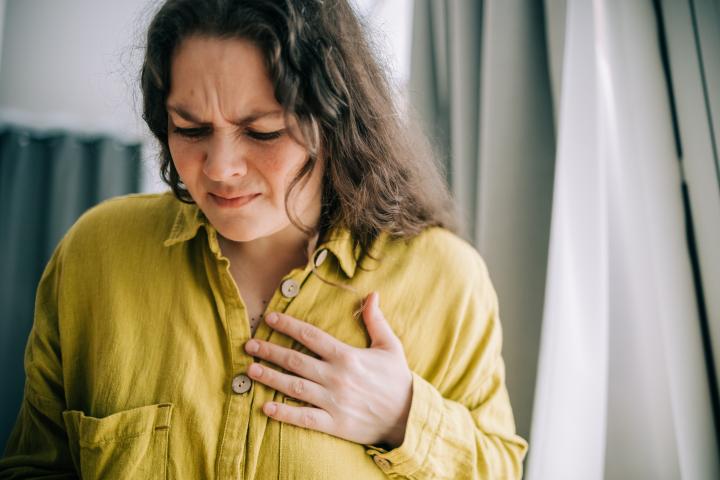 una mujer con la mano en el pecho