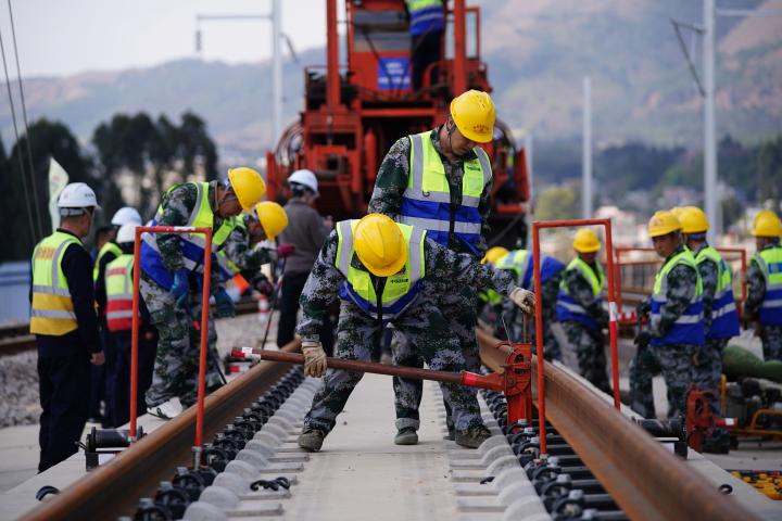 Trabajadores instalando vías de ferrocarril de alta velocidad en China