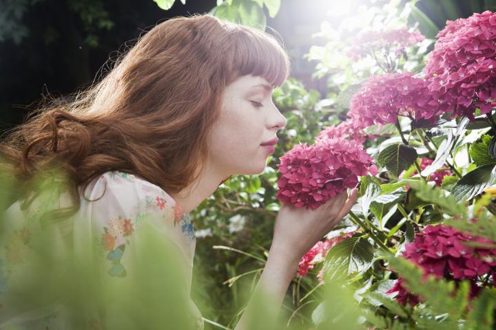 Una mujer huele una flor