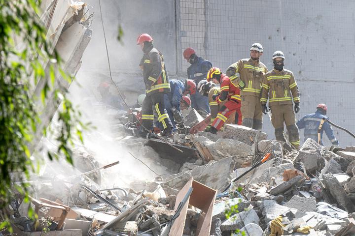 Agentes de rescate trabajan en un edificio en ruinas tras un ataque ruso con drones en Kiev (Ucrania).