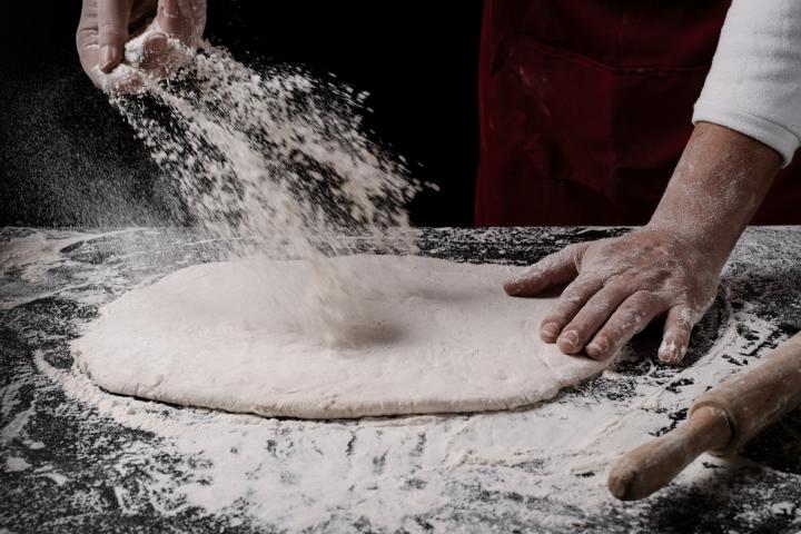 Un cocinero elaborando una pizza
