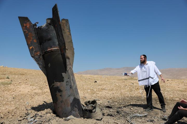 Un judío ultraortodoxo observa los restos de un misil iraní que aterrizó en un campo abierto junto al asentamiento de Mevo'ot Yericho en Cisjordania (Palestina), el 08 de junio de 2026.
