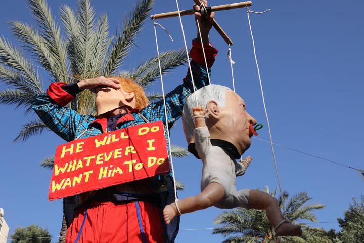 Un manifestante porta un guiñol del primer ministro de Israel, Benjamin Netanyahu, y un cartel que dice: "Hará lo que yo quiera que haga", una frase del norteamericano Donald Trump, el 4 de junio de 2026, en Tel Aviv.