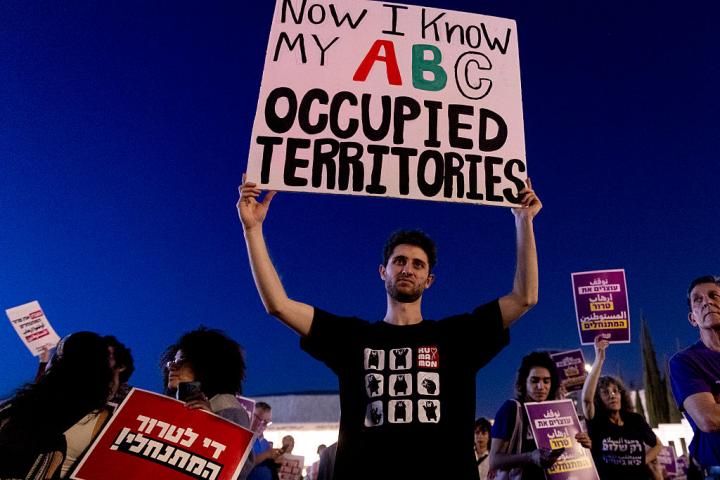 Manifestantes israelíes portan pancartas durante una protesta contra la violencia de los colonos en suelo de Cisjordania, el 16 de abril de 2026, en Tel Aviv (Israel).