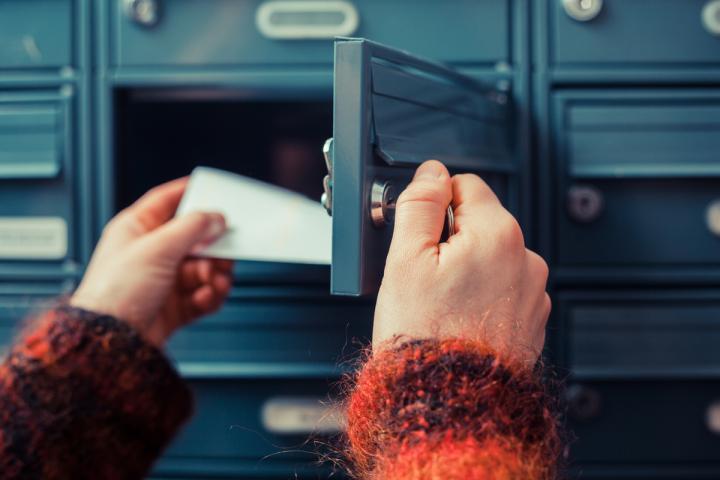 Una persona recogiendo una carta del buzón
