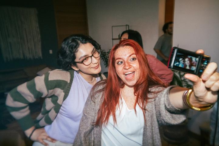 Dos jóvenes se hacen un selfie con una cámara digital.