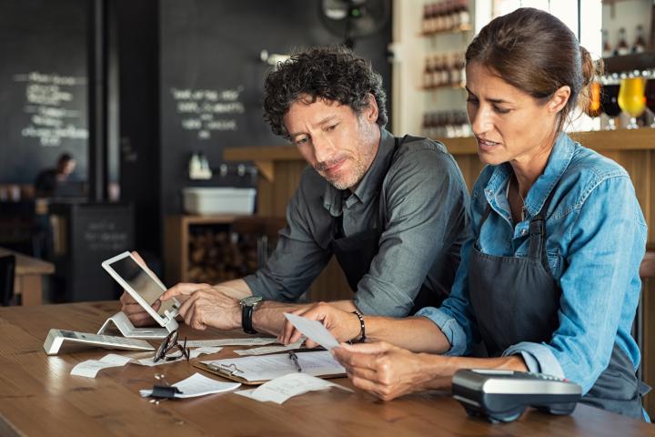 Empresarios de la hostelería revisando gastos y facturas.